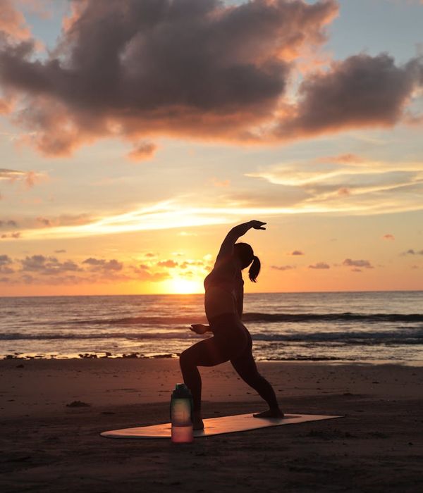 Silhouette of a person in a balanced pose at sunrise.